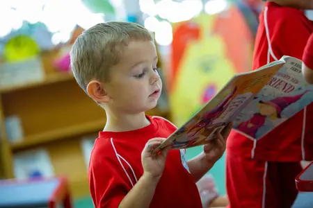 Lower School Boy in the library reading to himself
